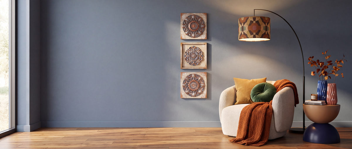 Cozy fall reading corner with an earth tone arc floor lamp, cream armchair, rust knit throw, ripple vases and sculptural wall art